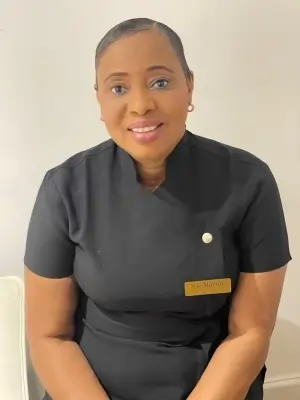 Nse Murray, Founder and Foot Health Practitioner at Alicegate, smiling warmly in a professional black uniform.